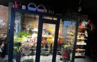 холодильник для квітів у квітковому салоні зі скляною вітриною